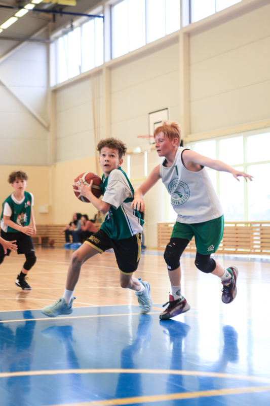 Puiši spēlē basketbola sporta zālē