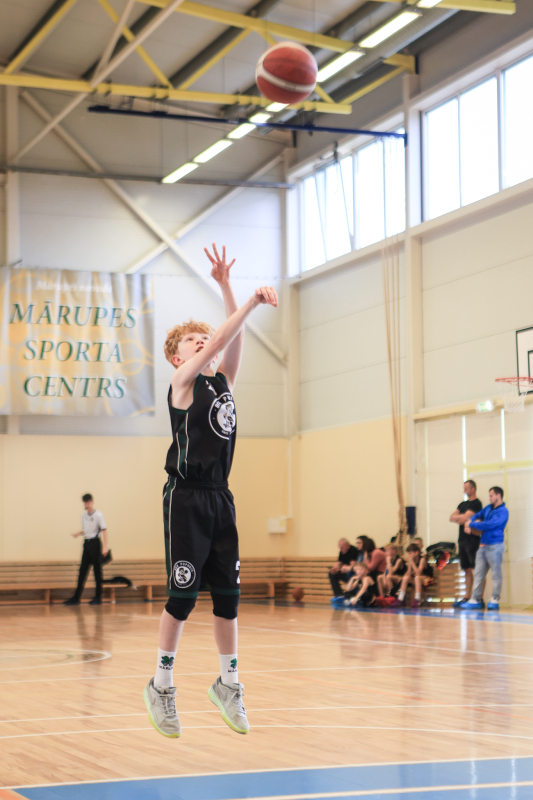 Puiši spēlē basketbola sporta zālē