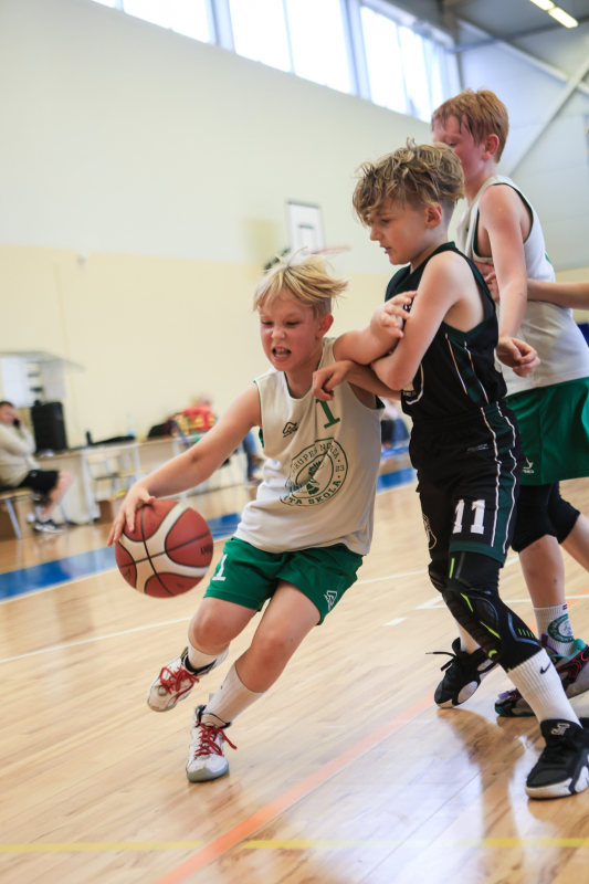 Puiši spēlē basketbola sporta zālē