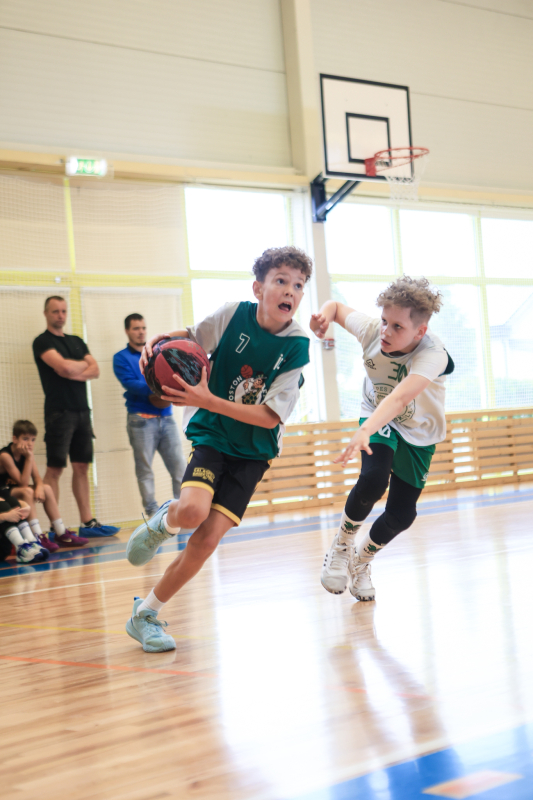 Puiši spēlē basketbola sporta zālē