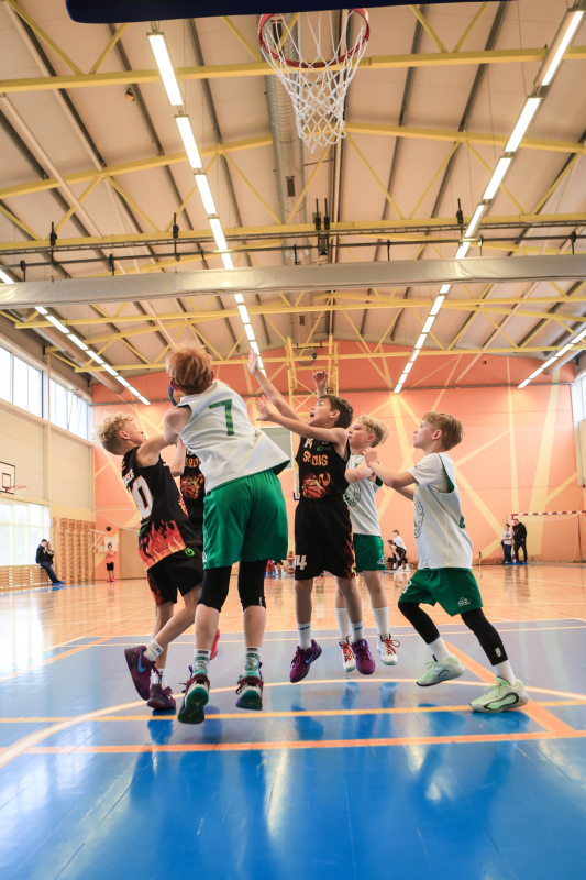 Puiši spēlē basketbola sporta zālē