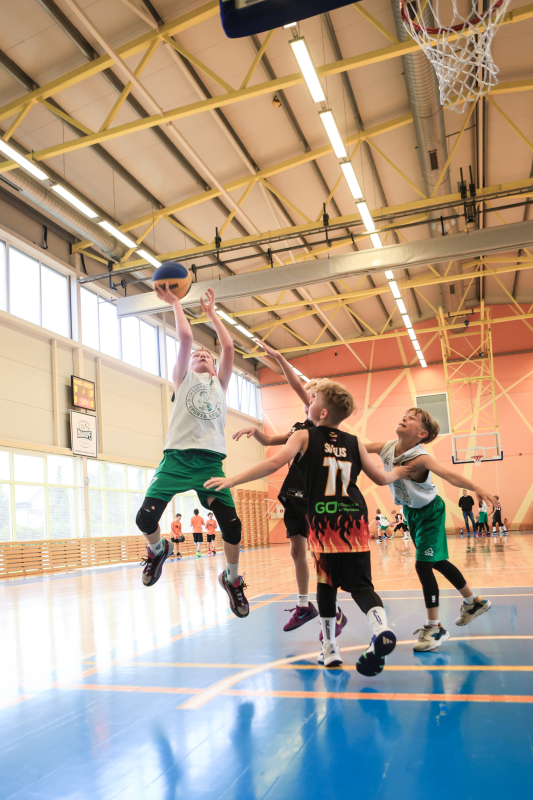 Puiši spēlē basketbola sporta zālē