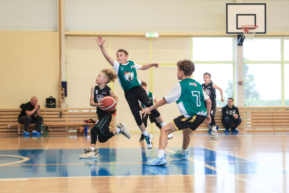Puiši spēlē basketbola sporta zālē