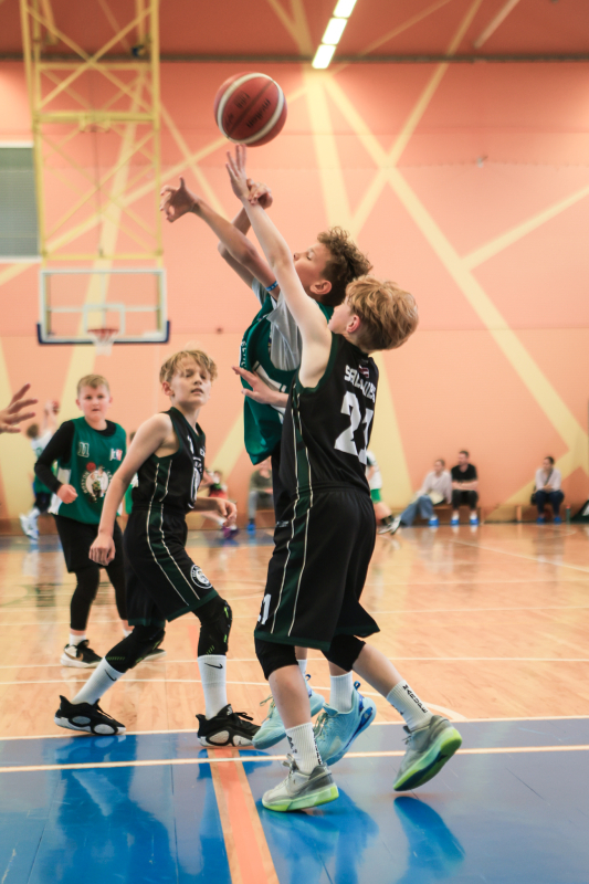 Puiši spēlē basketbola sporta zālē