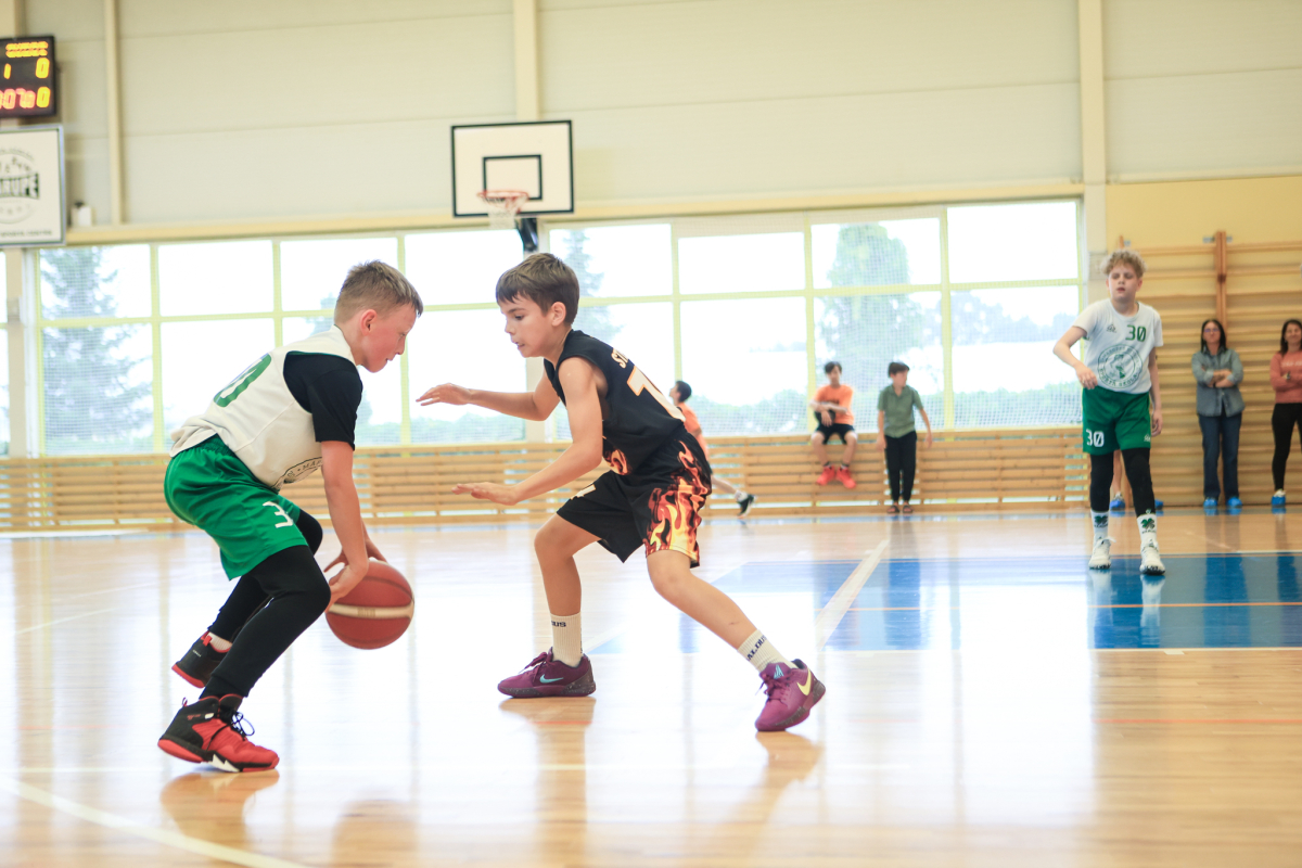 Puiši spēlē basketbola sporta zālē