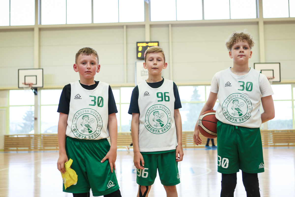 Puiši spēlē basketbola sporta zālē
