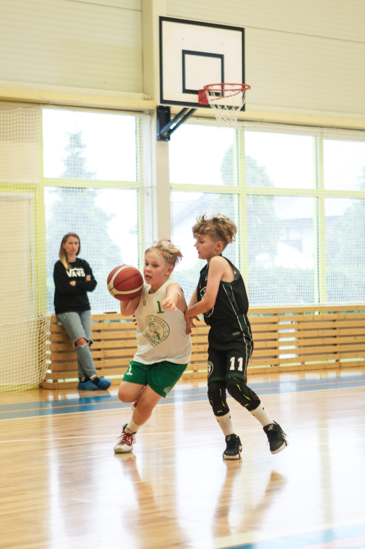 Puiši spēlē basketbola sporta zālē