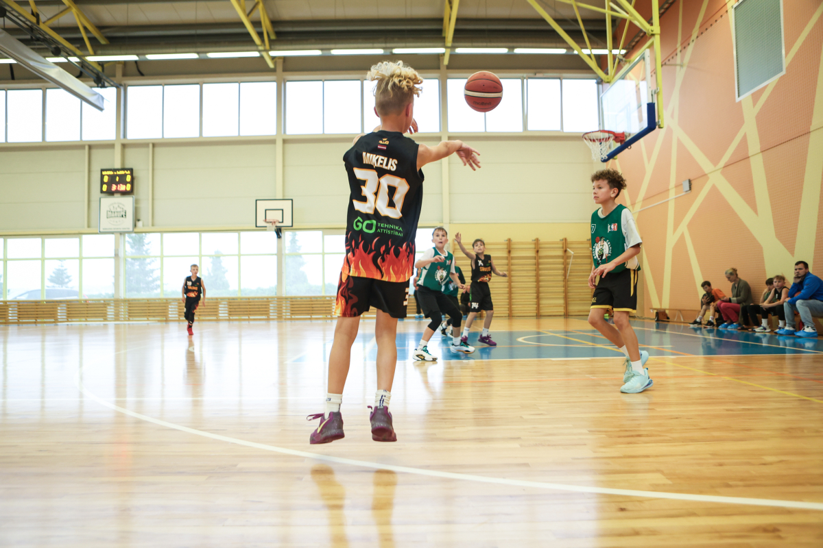 Puiši spēlē basketbola sporta zālē