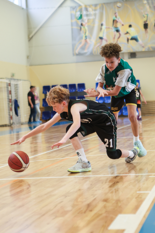 Puiši spēlē basketbola sporta zālē