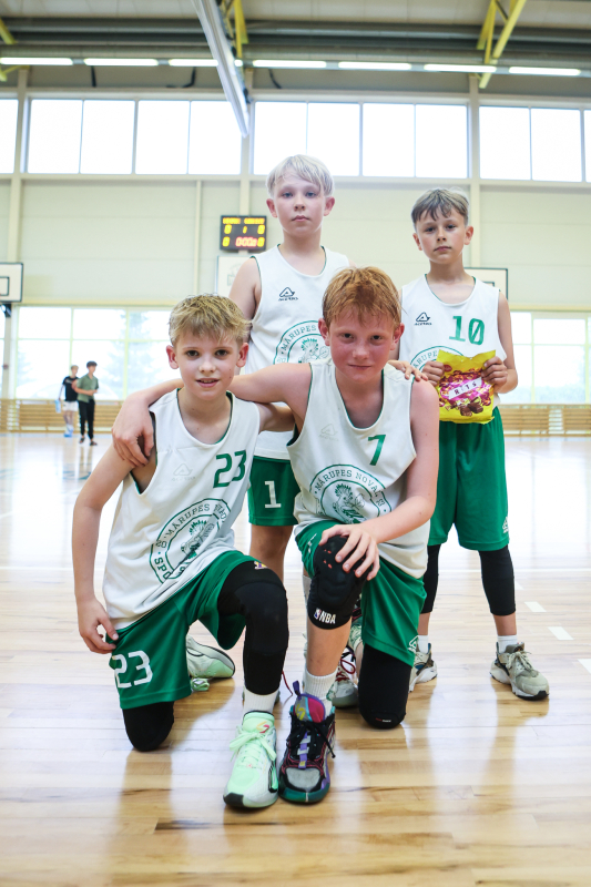 Puiši spēlē basketbola sporta zālē