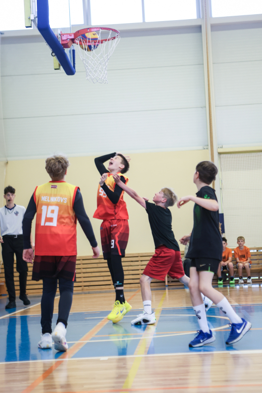 Puiši spēlē basketbola sporta zālē