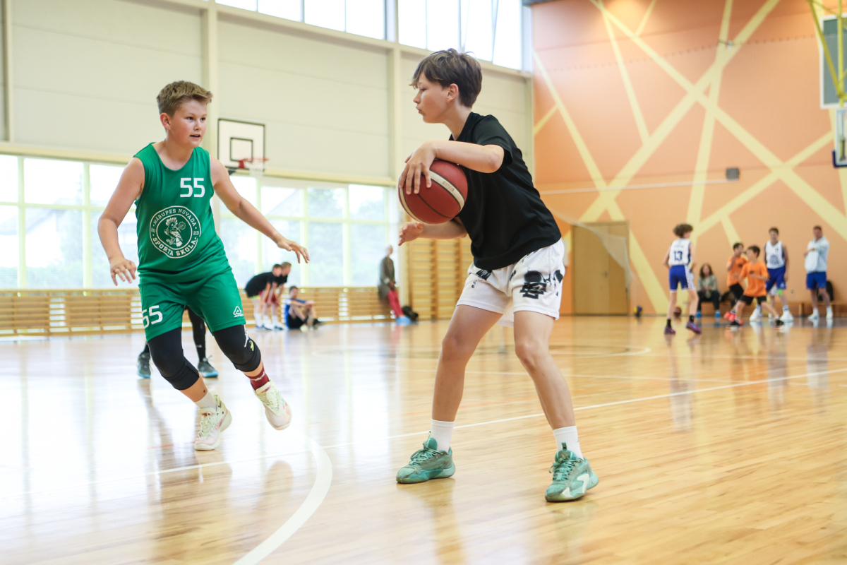 Puiši spēlē basketbola sporta zālē