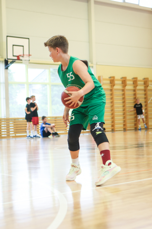 Puiši spēlē basketbola sporta zālē