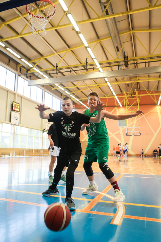 Puiši spēlē basketbola sporta zālē