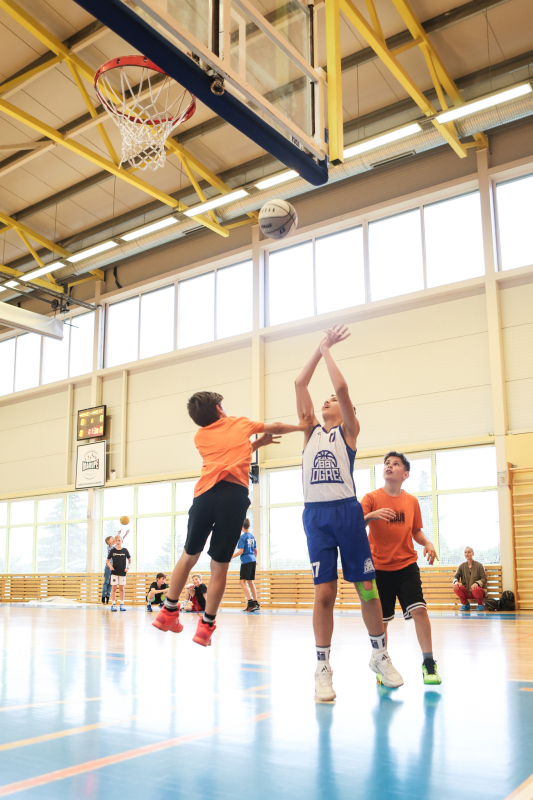 Puiši spēlē basketbola sporta zālē