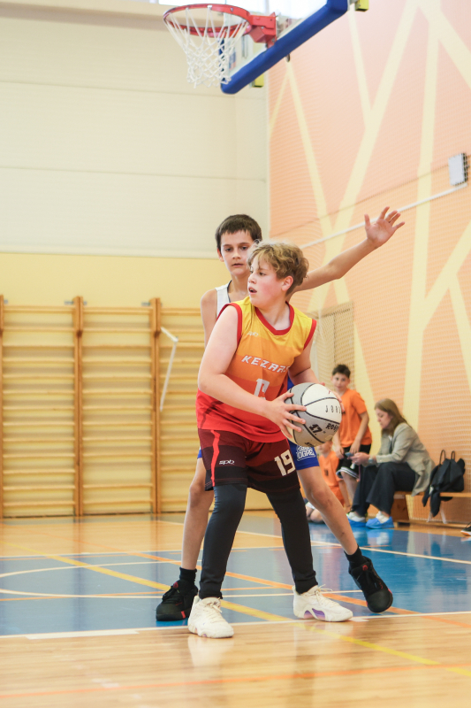 Puiši spēlē basketbola sporta zālē