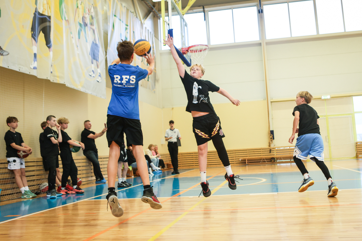 Puiši spēlē basketbola sporta zālē