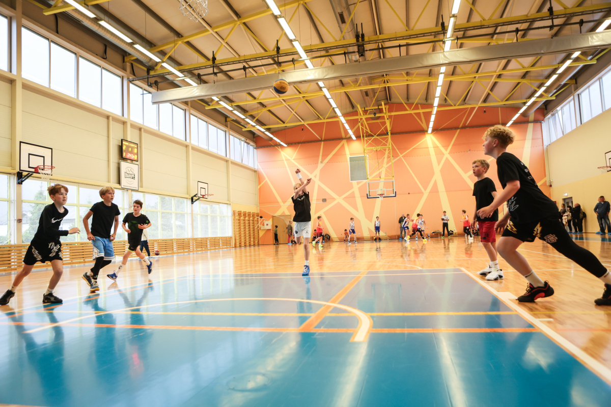 Puiši spēlē basketbola sporta zālē