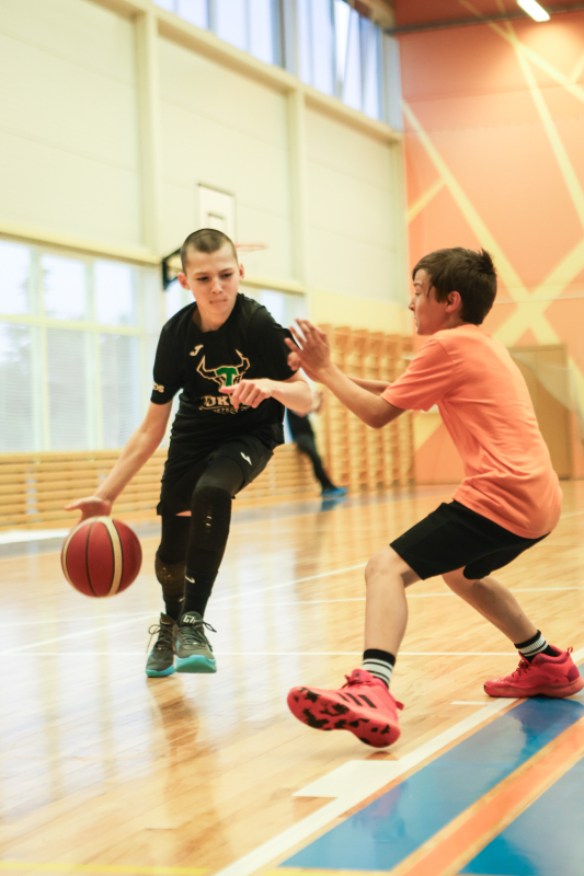 Puiši spēlē basketbola sporta zālē