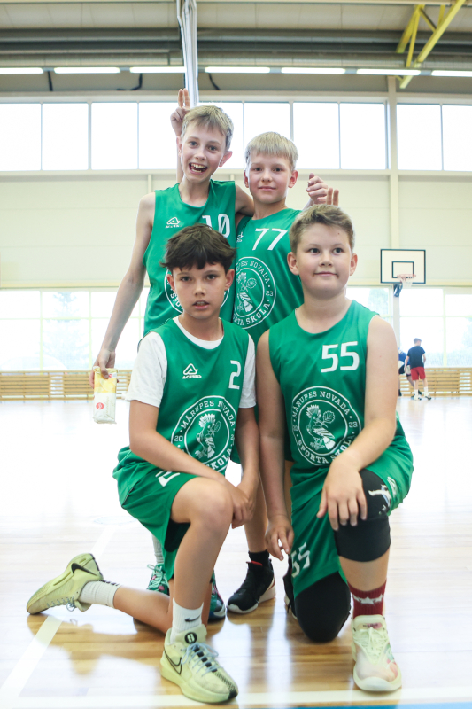 Puiši spēlē basketbola sporta zālē