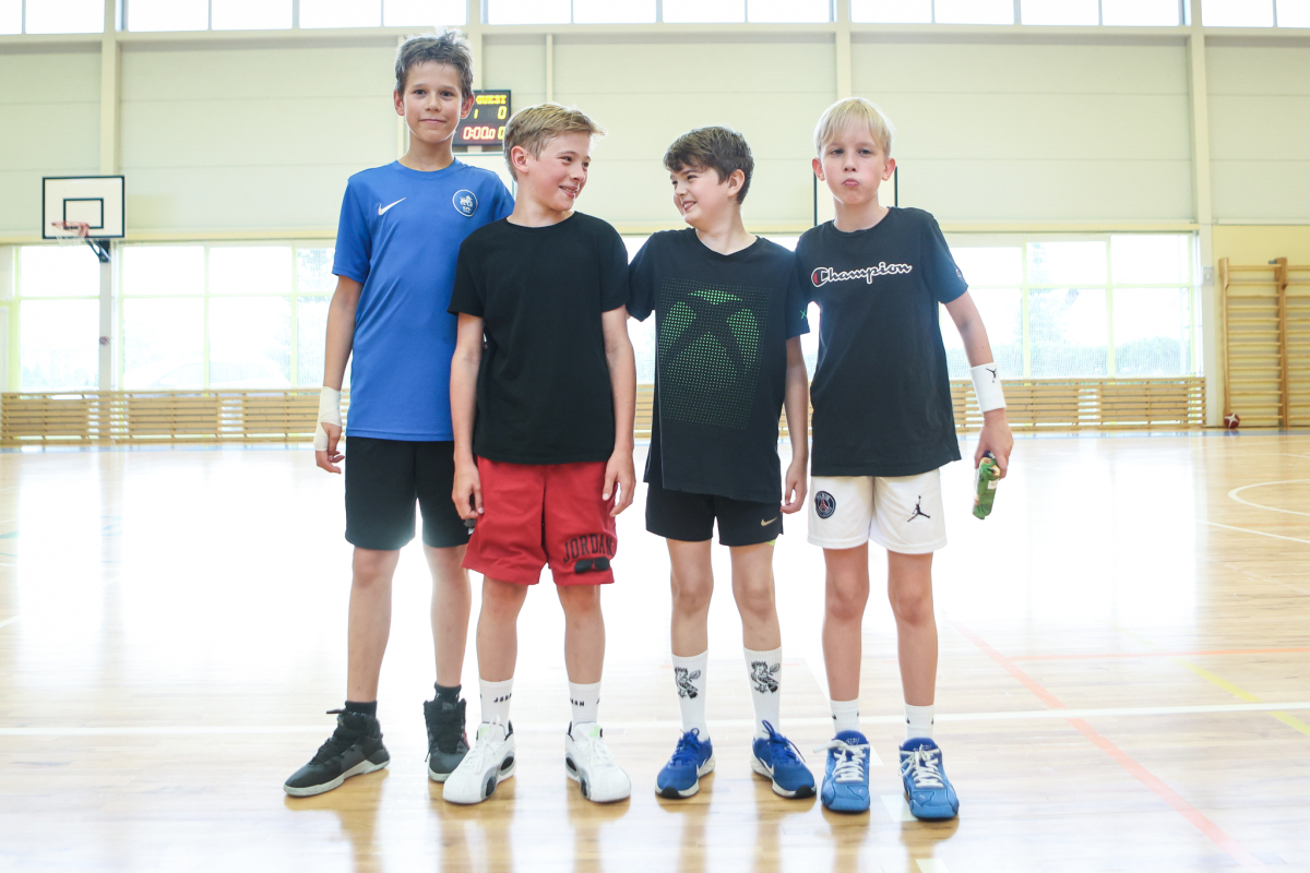 Puiši spēlē basketbola sporta zālē