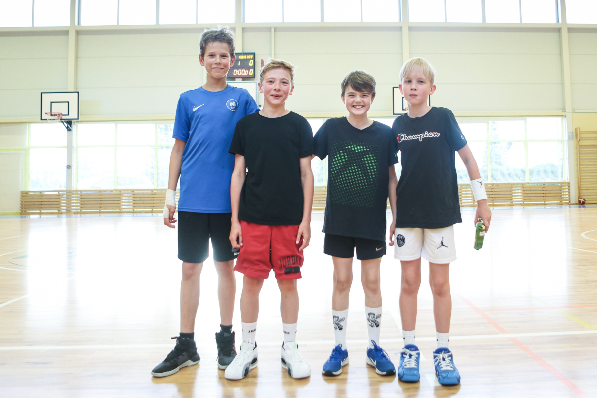 Puiši spēlē basketbola sporta zālē