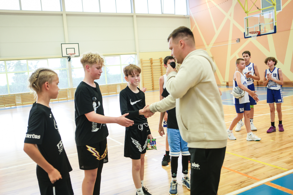 Puiši spēlē basketbola sporta zālē