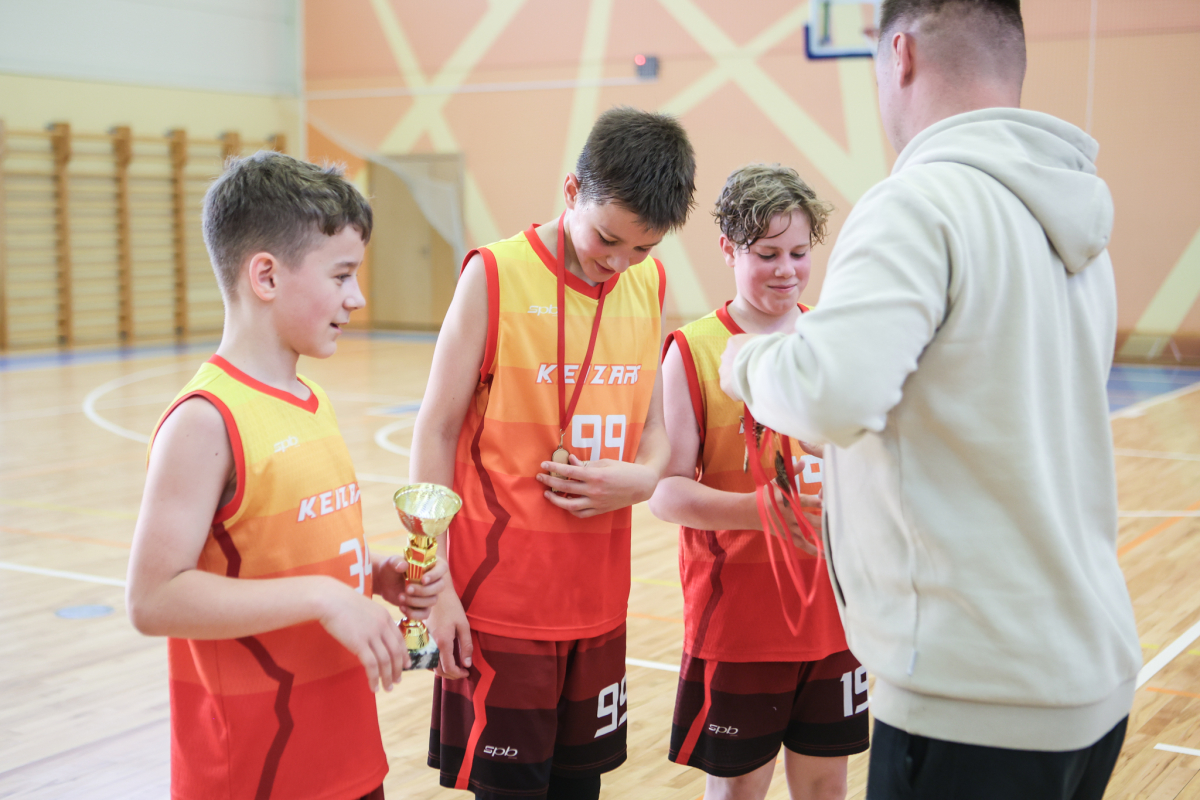 Puiši spēlē basketbola sporta zālē
