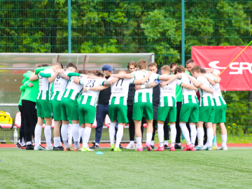 Futbolisti sporta tērpos apķērusies zaļā zālienā