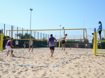 Cilvēki spēlē pludmales volejbolu