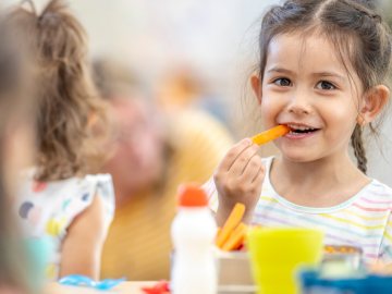 Meitene smaida un ēd burkānu