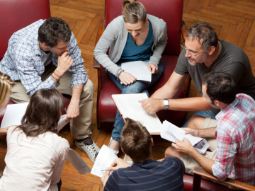 Cilvēki apsēdušies aplī