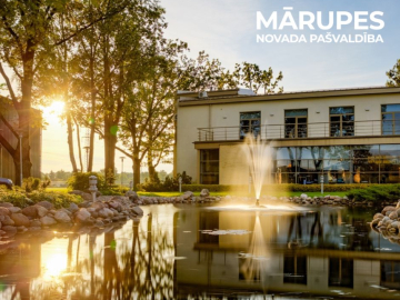 ēka ar kokiem priekšā un vakara saules stari