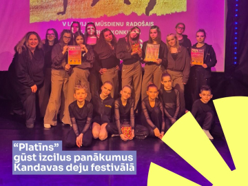 violetas noskaņas bilde ar bērniem un jauniešiem uz skatuves, kurus apspīd violeta gaisma