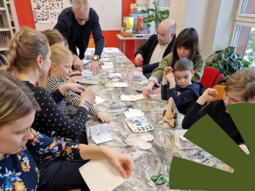 Mirklis no dabas piezīmju darbnīcām bibliotēkā, bērni kopā ar vecākiem darbojas pie liela galda