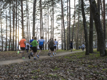 Cilvēki skrien mežā