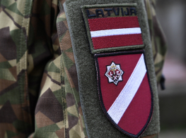 Zemessardzes ekipējuma fragments ar uzšuvi Latvijas karoga krāsā un ģerboni