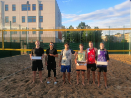 Volejbola spēlētāji pludmales volejbola laukumā