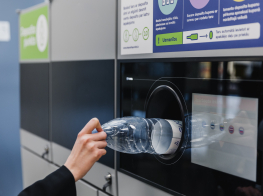 Roka, kurā ir plastmasas pudele, kas tiek nodota depozīta taromātā