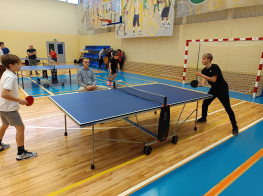 Divi puiši spēlē galda tenisu sporta zālē