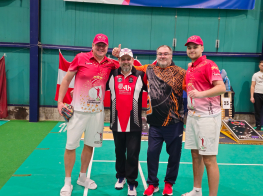 Četri vīrieši sporta tērpos stāv  sporta zālē