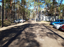 Autostāvlaukums ar automašīnām un kokiem