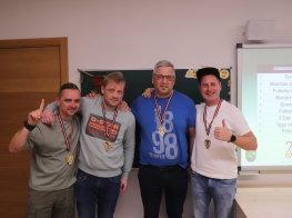 Četri cilvēki stāv skolas klasē