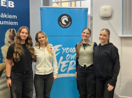 Četras jaunietes pie gaiša fona un projekta banera