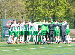 Futbolisti aplī stāv uz zāliena