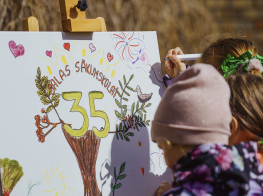 Bērns Salas sākumskolas jubilejā zīmē "35"