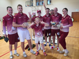 Cilvēki sporta kostīmos stāv sporta zālē