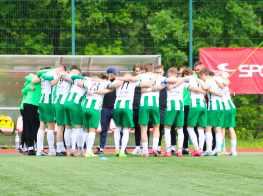 Futbolisti sporta tērpos apķērusies zaļā zālienā