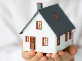 Mājas modelis, ko tur rokās