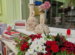 Ziedu kompozīcija, grāmatas un vāzes uz palodzes